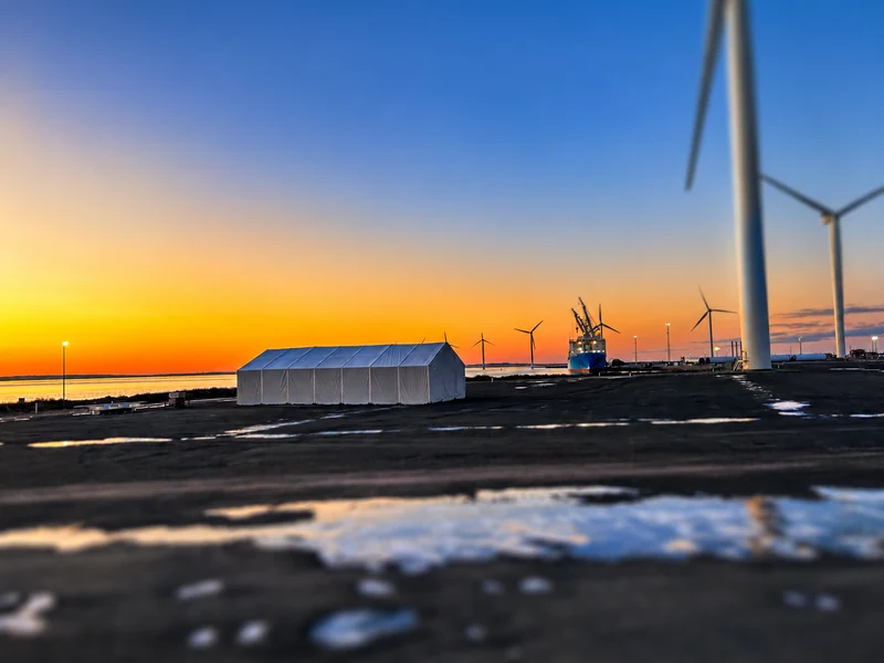 Port facilities and wind turbines at sunset